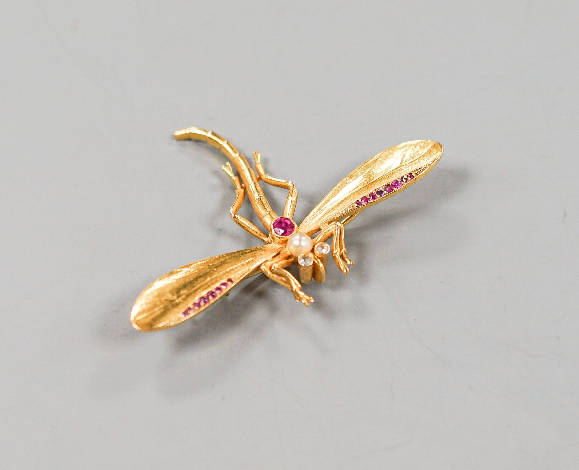 A yellow metal, ruby diamond and cultured pearl set dragonfly brooch, diameter 52mm, gross weight 8 grams.